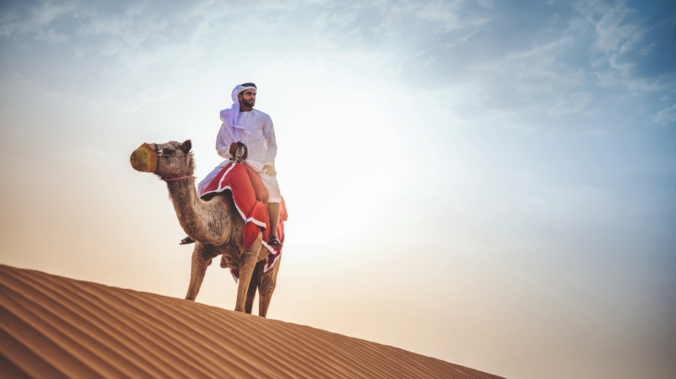 man riding camel in Dubai desert 